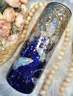 a blue and gold glittered vase sitting on top of a white fur covered floor