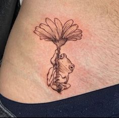 a tattoo on the side of a man's stomach shows a frog holding a flower