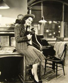 a black and white photo of a woman sitting at a table