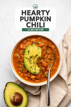 a bowl of hearty pumpkin chili next to an avocado