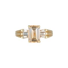 an emerald cut diamond ring with three baguets on each side and two bagsuetts in the middle