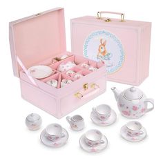 a pink tea set with matching cups and saucers in a box, next to it's contents