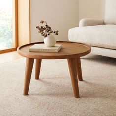 a coffee table with a book and vase on it