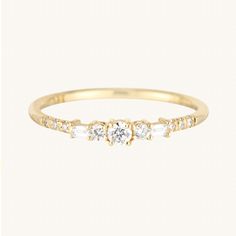 a yellow gold ring with three stones on the side and two diamonds in the middle