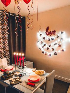 a dining room table with candles and pictures on the wall above it that says happy birthday