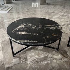 a black marble coffee table sitting on top of a tiled floor