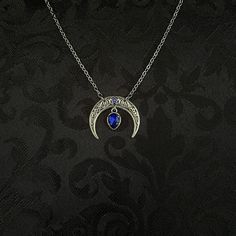 "This simple pendant features a richly detailed antiqued silver tone crescent, adorned with dazzling dark sapphire blue glass crystals. Pendant is 1 1/8\" wide and 1\" tall.  Necklace length is adjustable with soldered stainless steel cable chain, lobster clasp and extender. If you would like a different length, please send us a message. Matching headpiece, pendant and earrings are listed separately in our store. If you don't see items with a color you want, feel free to ask about availability." Dark Blue Jewelry Aesthetic, Blue Gothic Metal Necklace, Gothic Crescent Moon Charm Jewelry, Gothic Blue Metal Jewelry, Blue Gothic Metal Jewelry, Mystical Blue Moon Charm Jewelry, Blue Mystical Moon Charm Jewelry, Gothic Crescent Moon Phase Jewelry, Sapphire Necklace Simple