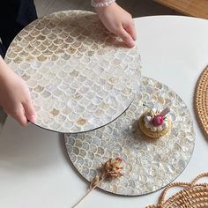 two plates with cakes on them sitting on top of a table next to wicker baskets