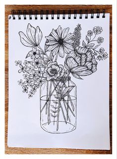 a drawing of flowers in a vase on top of a wooden table next to a spiral notebook