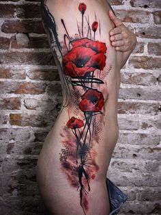 a woman's stomach with red flowers on it and black ink in the middle