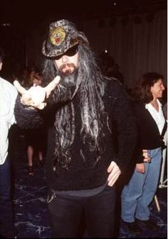 a man with long black hair wearing a pirate hat and holding something in his hand