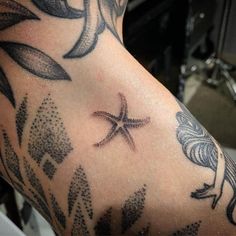 a close up of a person's arm with a star tattoo design on it