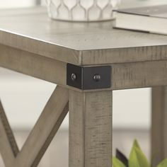 a close up of a table with a book on it and a plant in the background