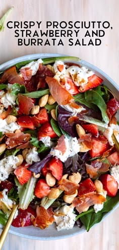 a salad in a bowl with strawberries and nuts