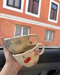 two coffee cups sitting in the passenger seat of a car