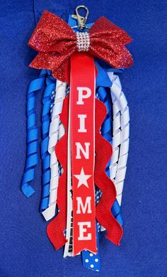 a red, white and blue ribbon with the word pin me on it hanging from a clip