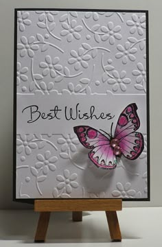 a white card with a pink butterfly on it and the words best wishes written in cursive writing