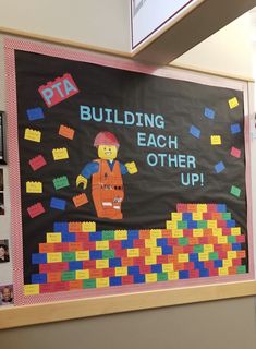 a bulletin board that says building each other up with legos on the front and back