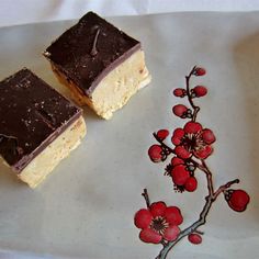 two pieces of cake sitting on top of a white plate next to a small flower