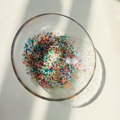 a glass filled with colorful sprinkles on top of a white countertop