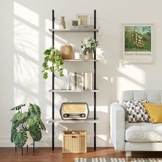 a living room filled with furniture and a book shelf next to a white couch on top of a hard wood floor