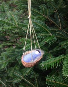 an ornament hanging from a pine tree with blue and white glass in it