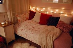 a bedroom with lights on the headboard and bed