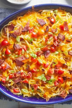 a casserole dish with bacon, tomatoes and cheese on it is ready to be eaten