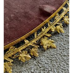 an ornately decorated table with gold leaves on it's legs and bottom edge