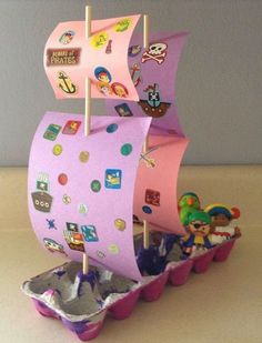 a paper boat with stickers on it sitting in some cupcakes