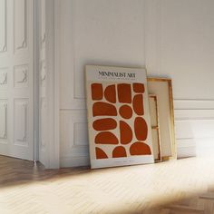 an orange and white poster sitting on top of a wooden floor next to a doorway