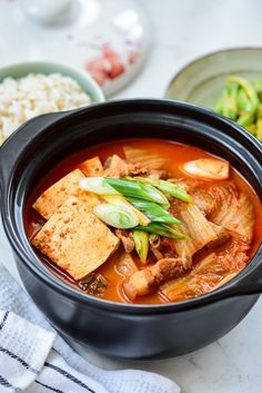 a bowl of soup with tofu and vegetables