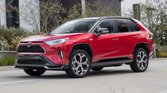 a red toyota rav parked in front of a building