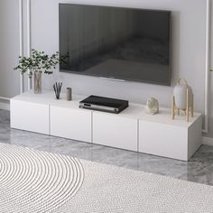 a flat screen tv sitting on top of a white entertainment center