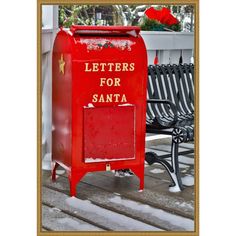 a red mailbox sitting on top of a snow covered wooden deck next to a bench