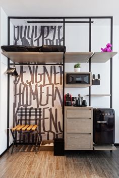 a kitchen with wooden floors and shelves filled with items on top of them, next to a microwave oven