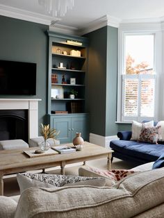 a living room filled with furniture and a flat screen tv mounted on a wall above a fire place