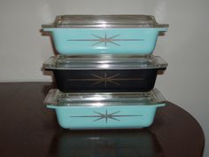 three glass casserole dishes stacked on top of each other, one black and one blue