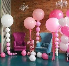 a room with balloons, chairs and chandeliers on the floor in front of a brick wall