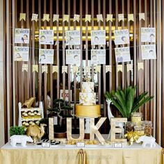 a table topped with a yellow cake and lots of gold decorations on top of it