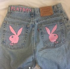 a pair of jeans with pink bunny ears painted on the front and back pockets