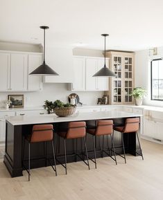 a large kitchen island with four chairs around it