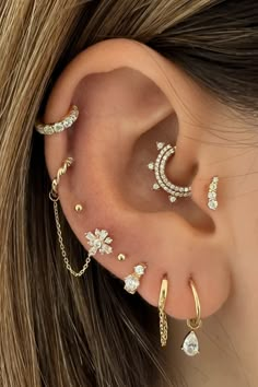 a woman's ear with four different types of piercings