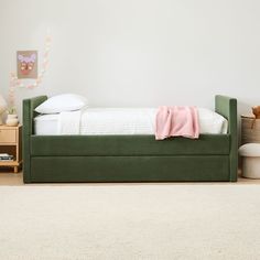 a green day bed with white sheets and pillows