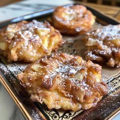 several pastries on a plate with powdered sugar