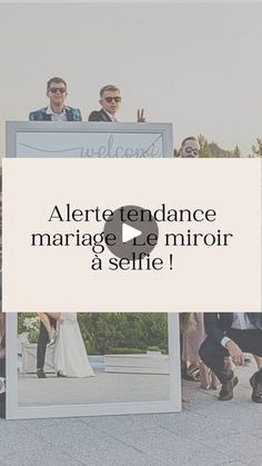 a group of people standing next to each other in front of a white sign that says alert endancee marriage de mirror a selfie