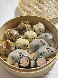 an assortment of sushi rolls in a bamboo steamer box with hello kitty faces on them