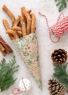 a cone filled with cinnamon sticks next to christmas decorations