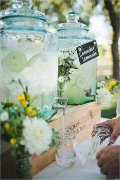 two mason jars filled with lemonade and cucumber are sitting on a table