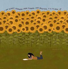 a person laying on the ground in front of a field of sunflowers